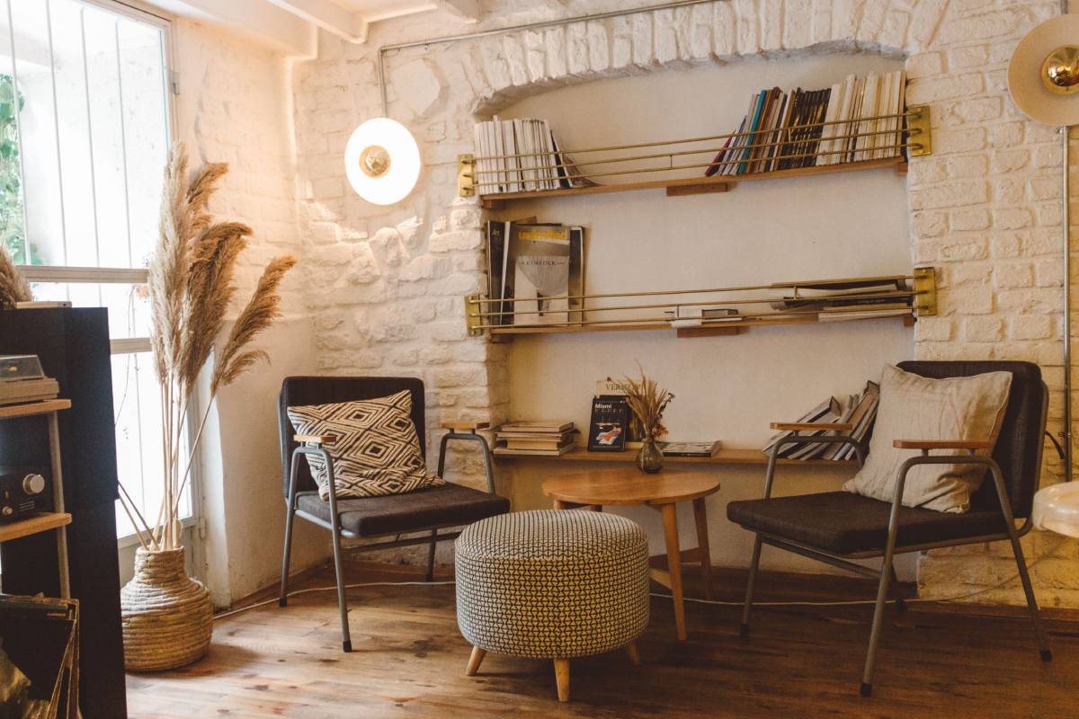 Two teal armchairs beside a tall wooden bookshelf with a floor lamp — affordable living room ideas on a budget