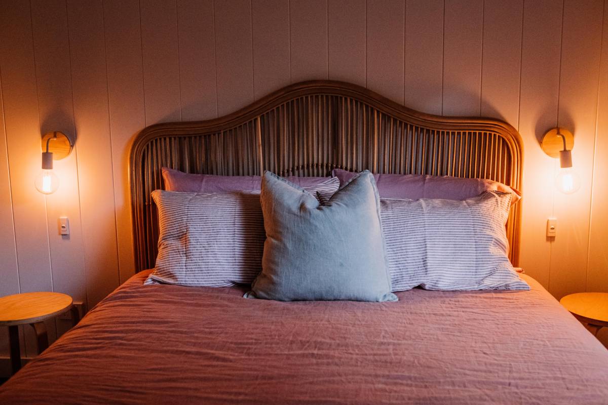 A layered "hotel bed" in a small bedroom with a neutral duvet, a folded throw, and stacked pillows — small bedroom decor ideas on a budget