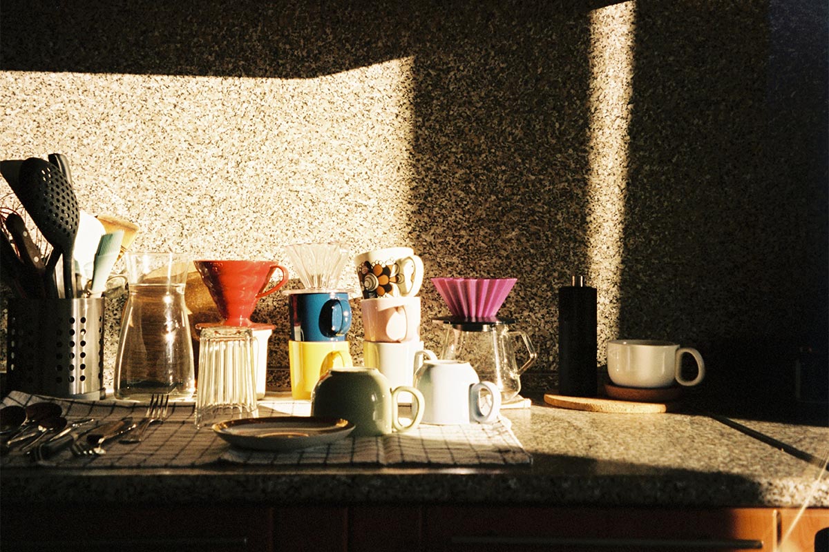 A clean, styled small rental kitchen counter with a peel-and-stick backsplash, a few matching jars, and warm lighting β small kitchen decor ideas on a budget