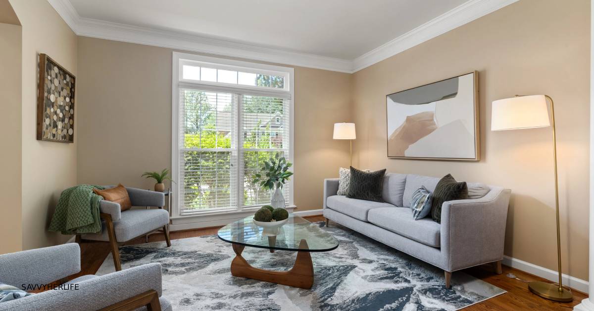 How to decorate your living room on a budget — a cozy styled living room with a large rug, a slipcovered couch, warm lamp lighting, and a plant in the corner