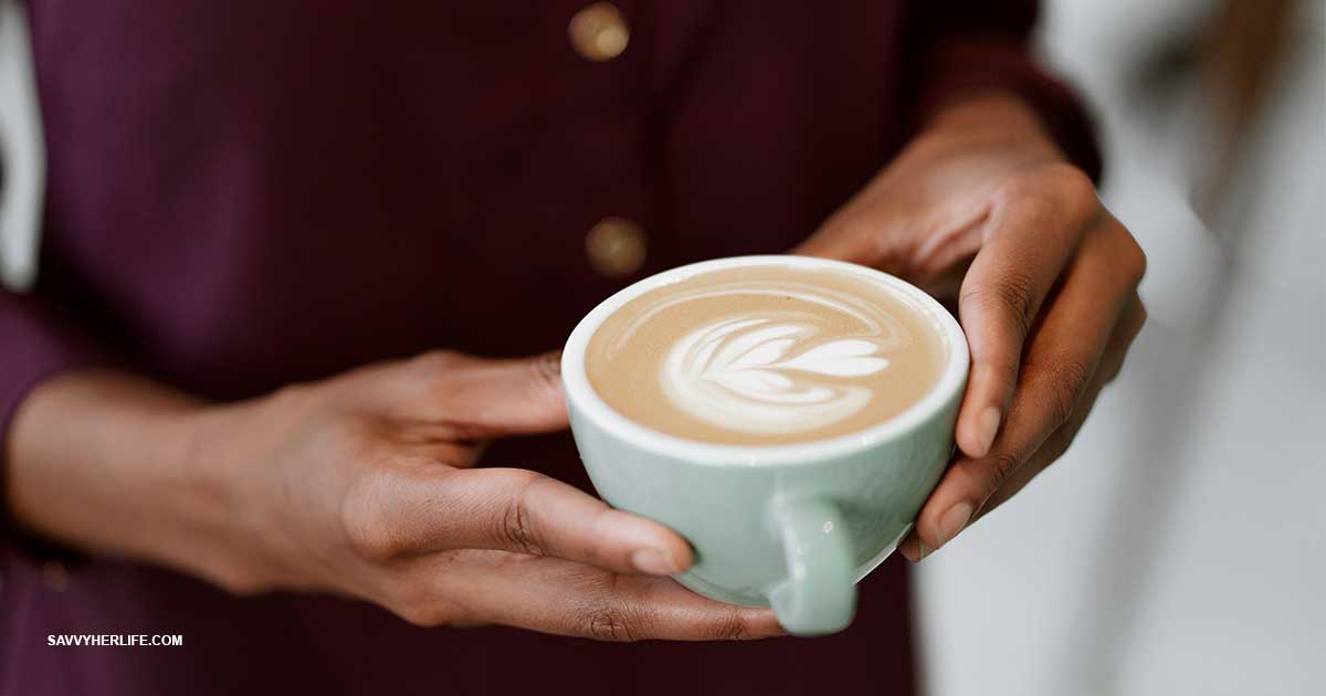 Morning routine on a budget — a calm morning setup with a coffee mug, open blinds, a glass of water, and a notebook on a small table