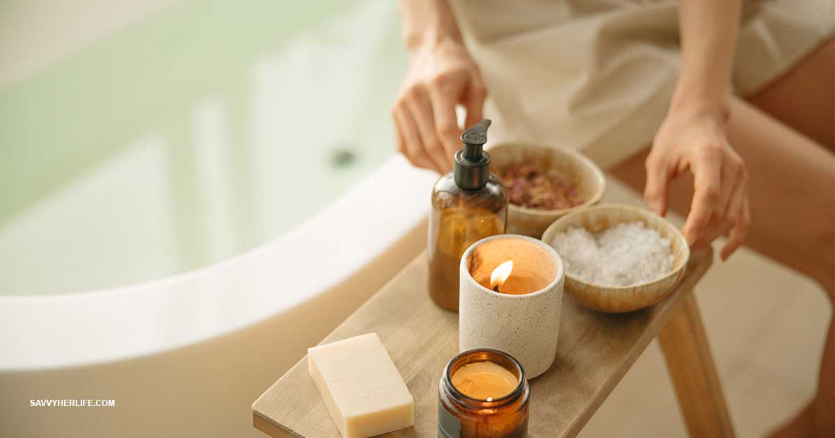 Self care ideas on a budget — a cozy at-home setup with a warm bath, a candle, a book, and soft candlelight